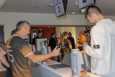 An Axess team member shows a guest the ticket check-in at the Axess gates